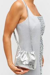 Profile view of model wearing the Oroton Gretel Metallic Mini Top Handle in Silver and Foil texture leather for Women .