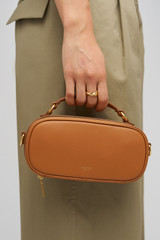 Profile view of model wearing the Oroton Margot Camera Bag in Dark Camel and Pebble Leather exterior for Women