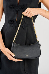 Profile view of model wearing the Oroton Eve Mini Baguette in Black and Pebble leather material for Women .