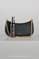 Profile view of model wearing the Oroton Eve Mini Baguette in Black and Pebble leather material for Women .