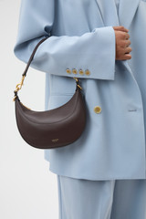 Profile view of model wearing the Oroton Florence Small Shoulder Bag in Mahogany and Premium smooth leather for Women .