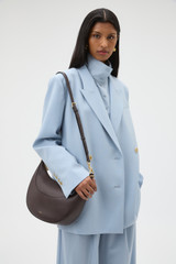 Profile view of model wearing the Oroton Florence Medium Hobo in Mahogany and Smooth leather material for Women .