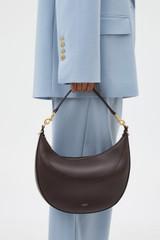 Profile view of model wearing the Oroton Florence Medium Hobo in Mahogany and Smooth leather material for Women .