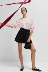 Profile view of model wearing the Oroton Belted Pleat Short in Black and 98% wool 2% elastane material for Women .