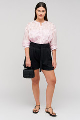 Profile view of model wearing the Oroton Belted Pleat Short in Black and 98% wool 2% elastane material for Women .