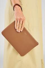 Profile view of model wearing the Oroton Eve Medium Pouch in Tan and Premium pebble leather for Women .