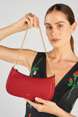 Profile view of model wearing the Oroton Eve Mini Baguette in Dark Ruby and Pebble leather material for Women .