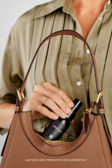 Profile view of model wearing the Oroton Dylan Mini Hobo in Tan and Premium pebble leather for Women .