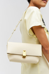 Profile view of model wearing the Oroton Etta Medium Clutch in Antique Cream and Premium smooth leather for Women . IP:4