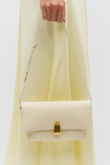 Profile view of model wearing the Oroton Etta Medium Clutch in Antique Cream and Premium smooth leather for Women . IP:3