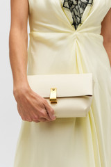 Profile view of model wearing the Oroton Etta Medium Clutch in Antique Cream and Premium smooth leather for Women . IP:2