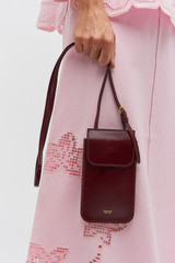 Profile view of model wearing the Oroton Margot Phone Crossbody in Currant and Glossy crackle leather for Women .