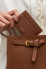 Profile view of model wearing the Oroton Margot Card Sleeve in Whiskey and Premium pebble leather for Women .