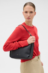 Profile view of model wearing the Oroton Dorit Small Hobo Bag in Black and Premium pebble leather for Women .
