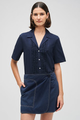 Profile view of model wearing the Oroton Wrap Drill Mini Skirt in North Sea and 100% Cotton for Women .