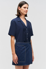 Profile view of model wearing the Oroton Wrap Drill Mini Skirt in North Sea and 100% Cotton for Women .