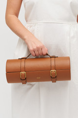 Profile view of model wearing the Oroton Billie Single Leather Wine Holder in Brandy and Pebble leather exterior for Women .