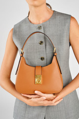 Profile view of model wearing the Oroton Yvonne Baguette in Tan and Premium pebble leather for Women .