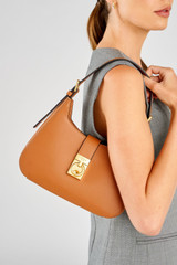 Profile view of model wearing the Oroton Yvonne Baguette in Tan and Premium pebble leather for Women .