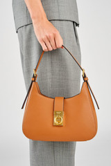Profile view of model wearing the Oroton Yvonne Baguette in Tan and Premium pebble leather for Women .