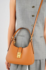 Profile view of model wearing the Oroton Yvonne Baguette in Tan and Premium pebble leather for Women .