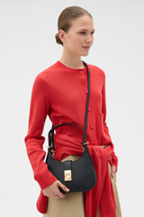 Profile view of model wearing the Oroton Yvonne Baguette in Black and Premium pebble leather for Women .