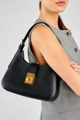 Profile view of model wearing the Oroton Yvonne Baguette in Black and Premium pebble leather for Women .