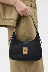 Profile view of model wearing the Oroton Yvonne Baguette in Black and Premium pebble leather for Women .