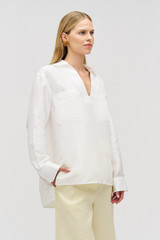 Profile view of model wearing the Oroton Tunic Shirt in Antique White and 100% silk for Women .