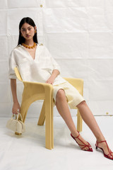 Profile view of model wearing the Oroton Tunic Shirt in Antique White and 100% silk for Women .