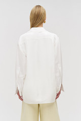 Profile view of model wearing the Oroton Tunic Shirt in Antique White and 100% silk for Women .