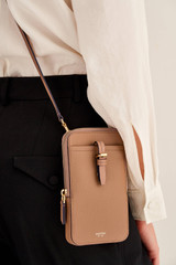Profile view of model wearing the Oroton Dylan Phone Crossbody in Tan and Premium pebble leather for Women .