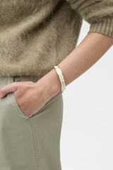Profile view of model wearing the Oroton Heather Wide Enamel Bangle in Cream and Premium brass material for Women .