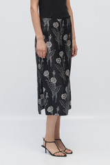 Profile view of model wearing the Oroton Graphic Dandelion Skirt in Black and 100% Silk Twill for Women .