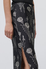 Profile view of model wearing the Oroton Graphic Dandelion Skirt in Black and 100% Silk Twill for Women .