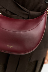 Profile view of model wearing the Oroton Florence Small Shoulder Bag in CURRANT and Premium smooth leather for Women .