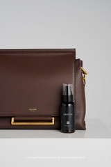 Profile view of model wearing the Oroton Elm Medium Satchel in Coffee Bean and Premium smooth pebble leather for Women .