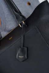Profile view of model wearing the Oroton IRIS MEDIUM TOTE in Black and Premium pebble leather for Women .