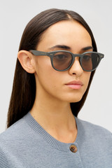 Profile view of model wearing the Oroton Fifer Sunglasses in Grey and Acetate for Women .