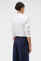 Profile view of model wearing the Oroton Crisp Poplin Shirt in White and 100% cotton fabric for Women .