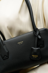Profile view of model wearing the Oroton Breeze Baguette in Black and Premium smooth leather for Women .