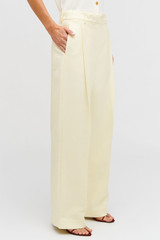 Profile view of model wearing the Oroton Pleat Slouch Pant in Lemon Butter and 58% viscose, 42% linen blend for Women .