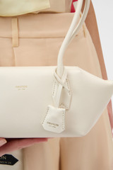 Profile view of model wearing the Oroton Breeze Baguette in Clotted Cream and Premium smooth leather for Women .