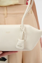 Profile view of model wearing the Oroton Breeze Baguette in Clotted Cream and Premium smooth leather for Women .