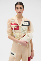 Profile view of model wearing the Oroton Breeze Baguette in Clotted Cream and Premium smooth leather for Women .