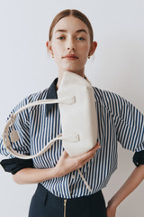 Profile view of model wearing the Oroton Breeze Baguette in Clotted Cream and Premium smooth leather for Women .
