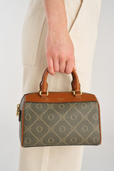 Profile view of model wearing the Oroton Harvey Signature Tiny Barrel Bag in Black/Cognac and Nylon canvas base cloth material with PVC coating (70% PVC, 30% polyester) for Women .