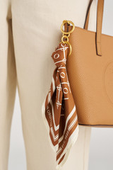 Profile view of model wearing the Oroton Eve Scarf Keyring in Cognac/Cream and 100% polyester fabric for Women .