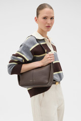 Profile view of model wearing the Oroton Dorit Small Hobo Bag in COFFEE BEAN and Premium pebble leather for Women .
