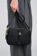 Profile view of model wearing the Oroton Dylan Camera Crossbody in Black and Premium pebble leather for Women .